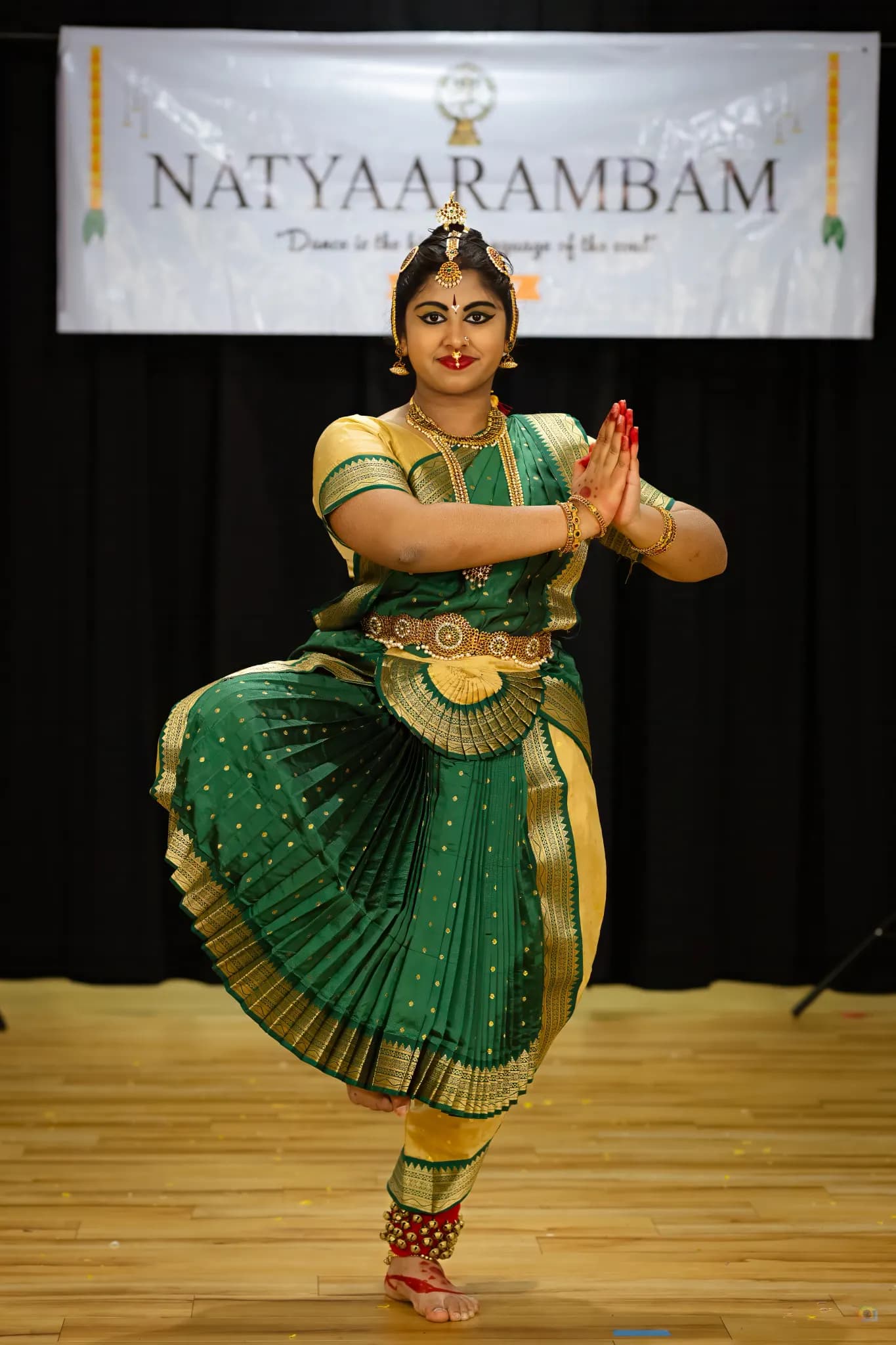Dancer in a red costume performing under warm stage light