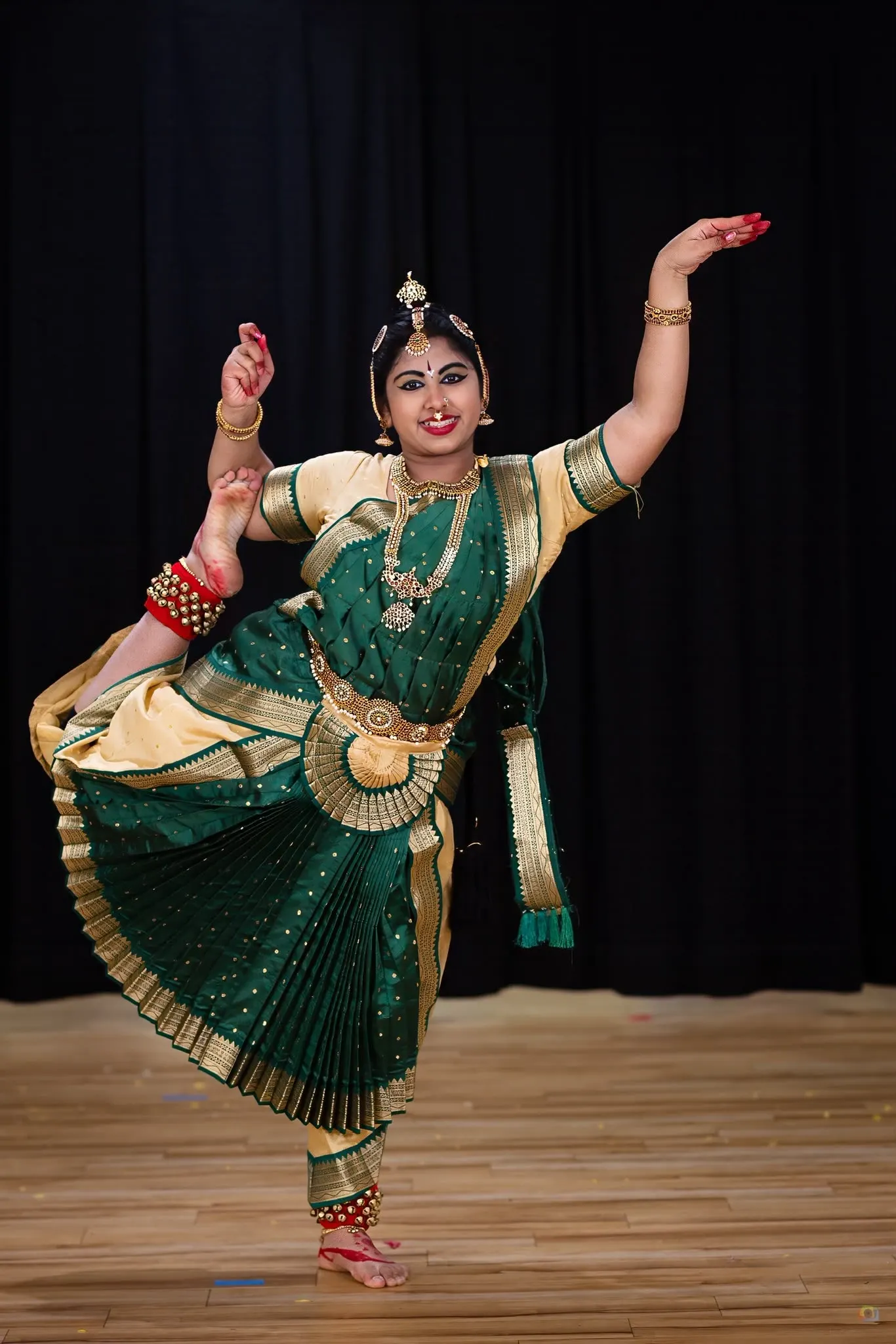A dancer's hand held in gyan mudra, adorned with bangles
